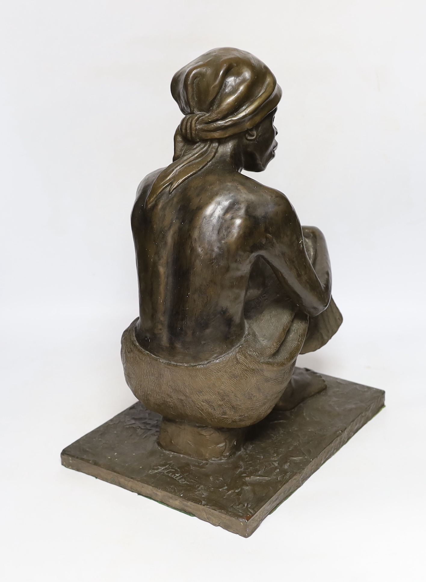 A bronzed resin figure of an African girl, signed J Cutler, 42cm high